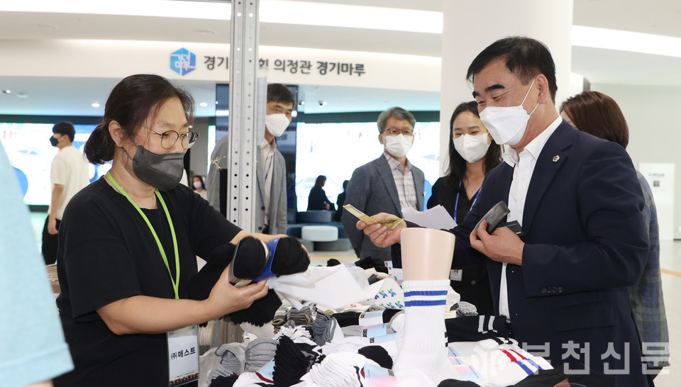 염종현 경기도의회 의장이 도내 개성공단 입주기업 판촉행사에 참석해 생산품을 구입하고 있다. 