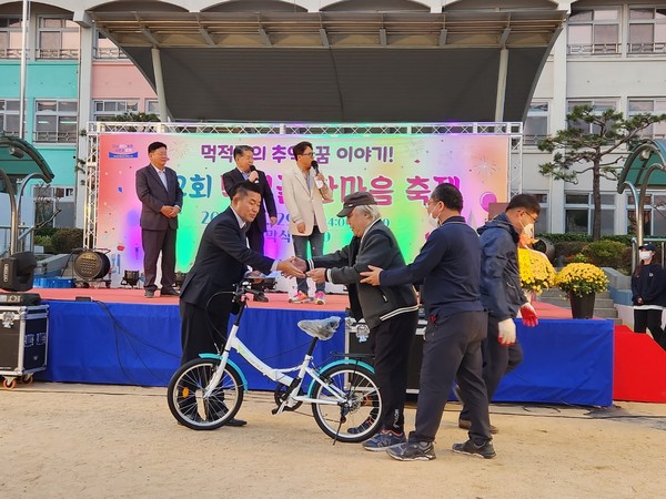 양왕덕 위원장이 축제에서 자전거를 상품으로 주민에게 전달하고 있는 모습
