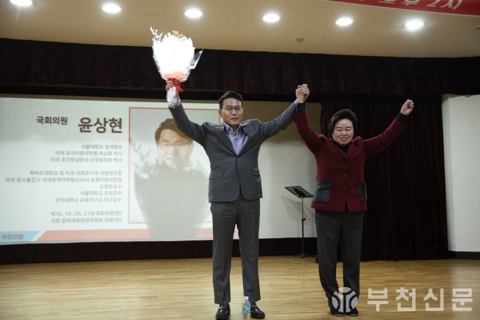 이음재 당협위원장과 윤상현 국회의원이 두 손을 들어 당원들에게 인사하고 있다.
